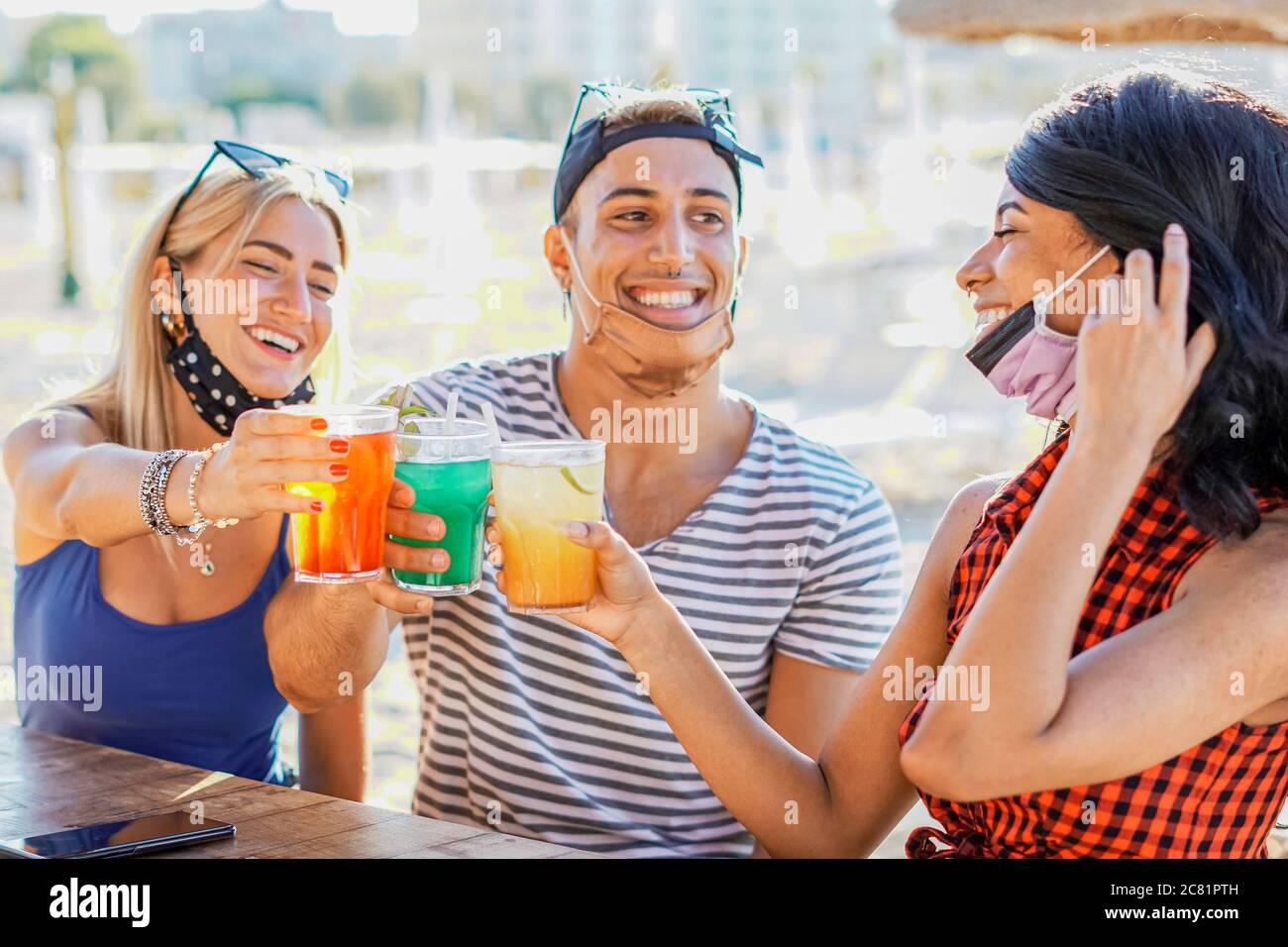 Les gens qui ont une fête sur une plage avec masque de visage - les jeunes qui boivent des cocktails en temps de coronavirus - les amis qui s'amusent au bar - Nouveau conc. De style de vie Banque D'Images