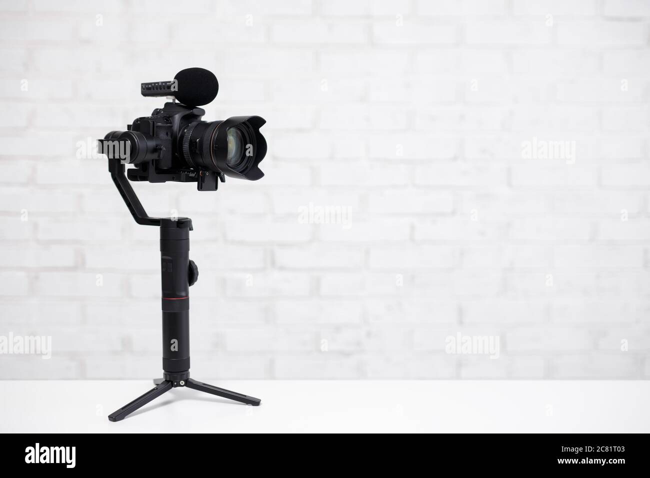 appareil photo reflex numérique moderne avec stabilisateur 3 axes et  microphone sur fond de mur en brique blanche avec espace de copie Photo  Stock - Alamy