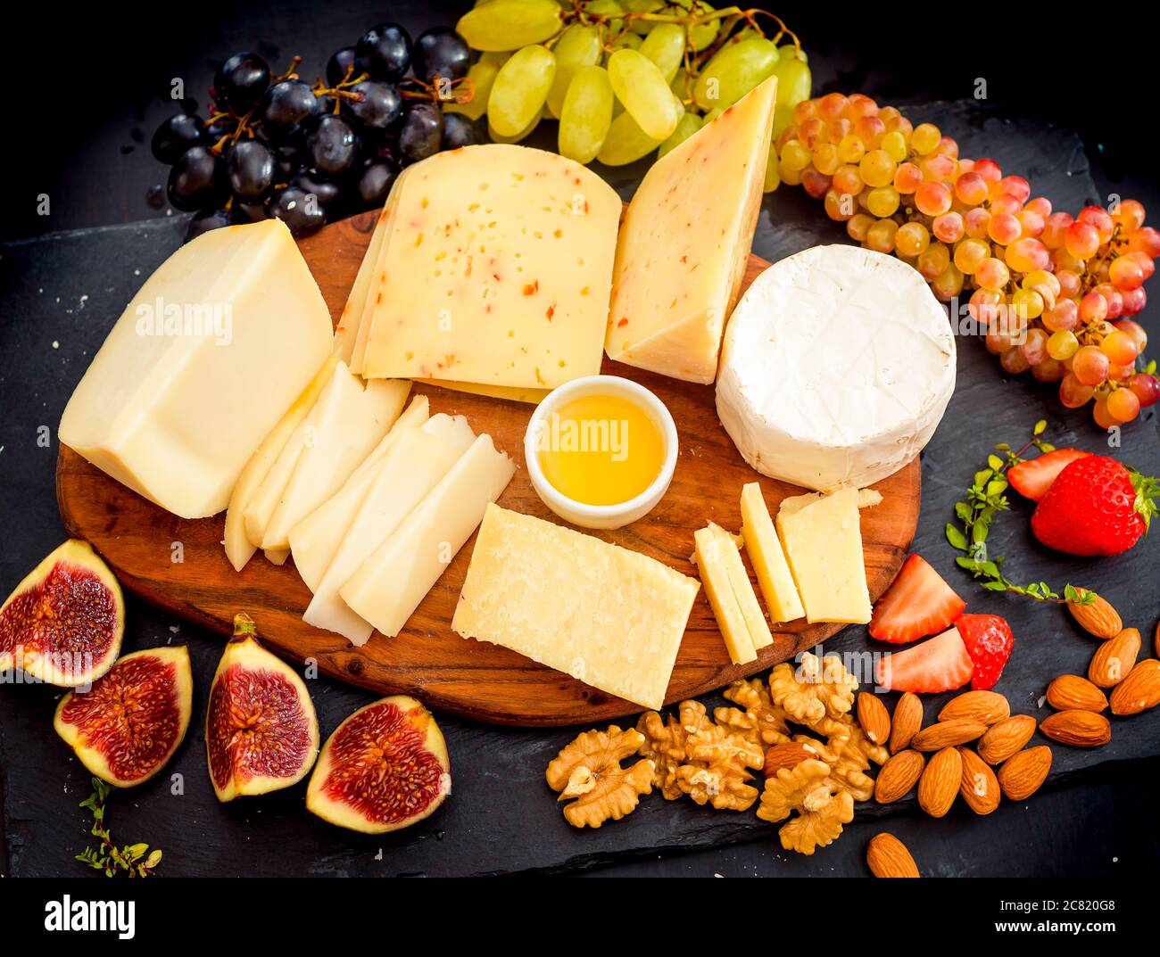 Assiette de fromage servi avec des raisins, confiture, figues, les craquelins et les écrous Banque D'Images