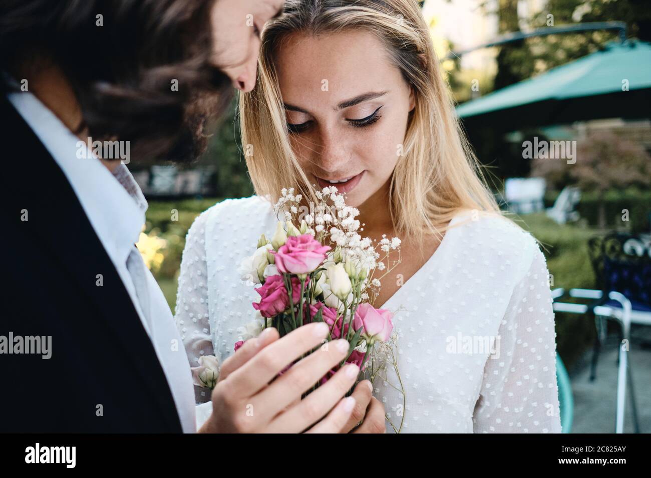 Gros plan romantique marié et magnifique mariée portant un bouquet de fleurs en plein air Banque D'Images