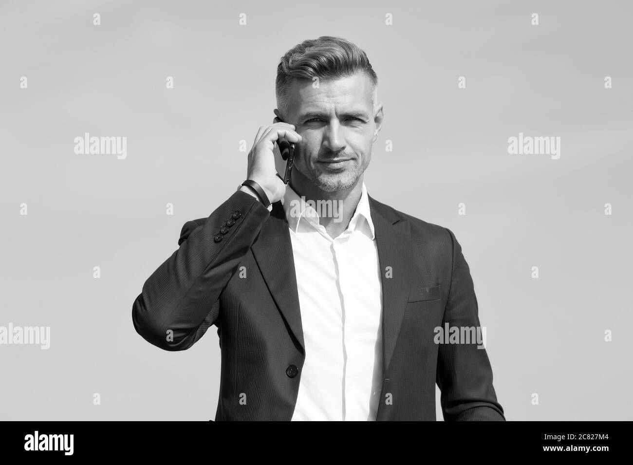 Bonjour, répondez au téléphone. Un homme d'affaires appelle sur le téléphone portable. Homme beau avec téléphone portable à l'extérieur. Communication d'entreprise. Téléphone à usage professionnel. 3 G. 4 G. Mode de vie mobile. Nouvelle technologie. Banque D'Images