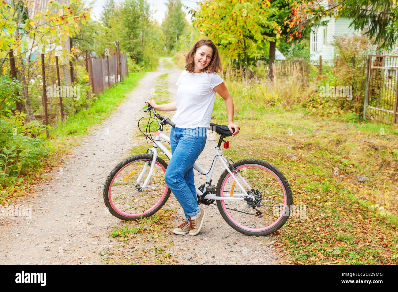 Young woman riding bicycle in summer city park à l'extérieur. Les personnes actives. Hipster girl vous détendre et rider moto. À vélo au travail au jour d'été. Location et de l'écologie concept de vie Banque D'Images