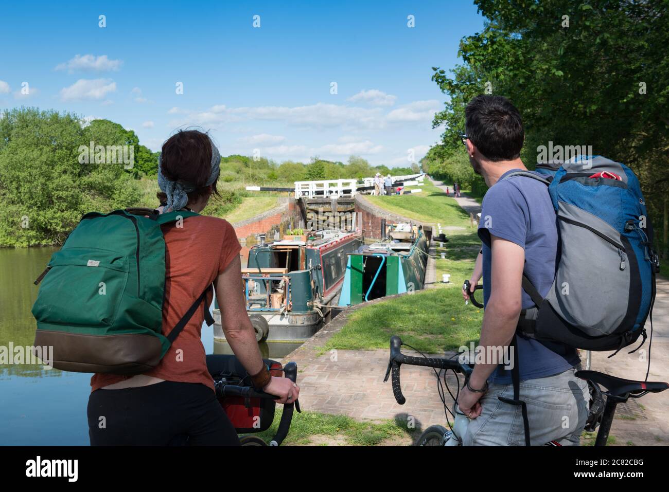 Un couple en voyage à vélo le long du canal Avon-Kennett s'est arrêté pour observer les écluses de Caen Hill dans le Wiltshire, au Royaume-Uni Banque D'Images