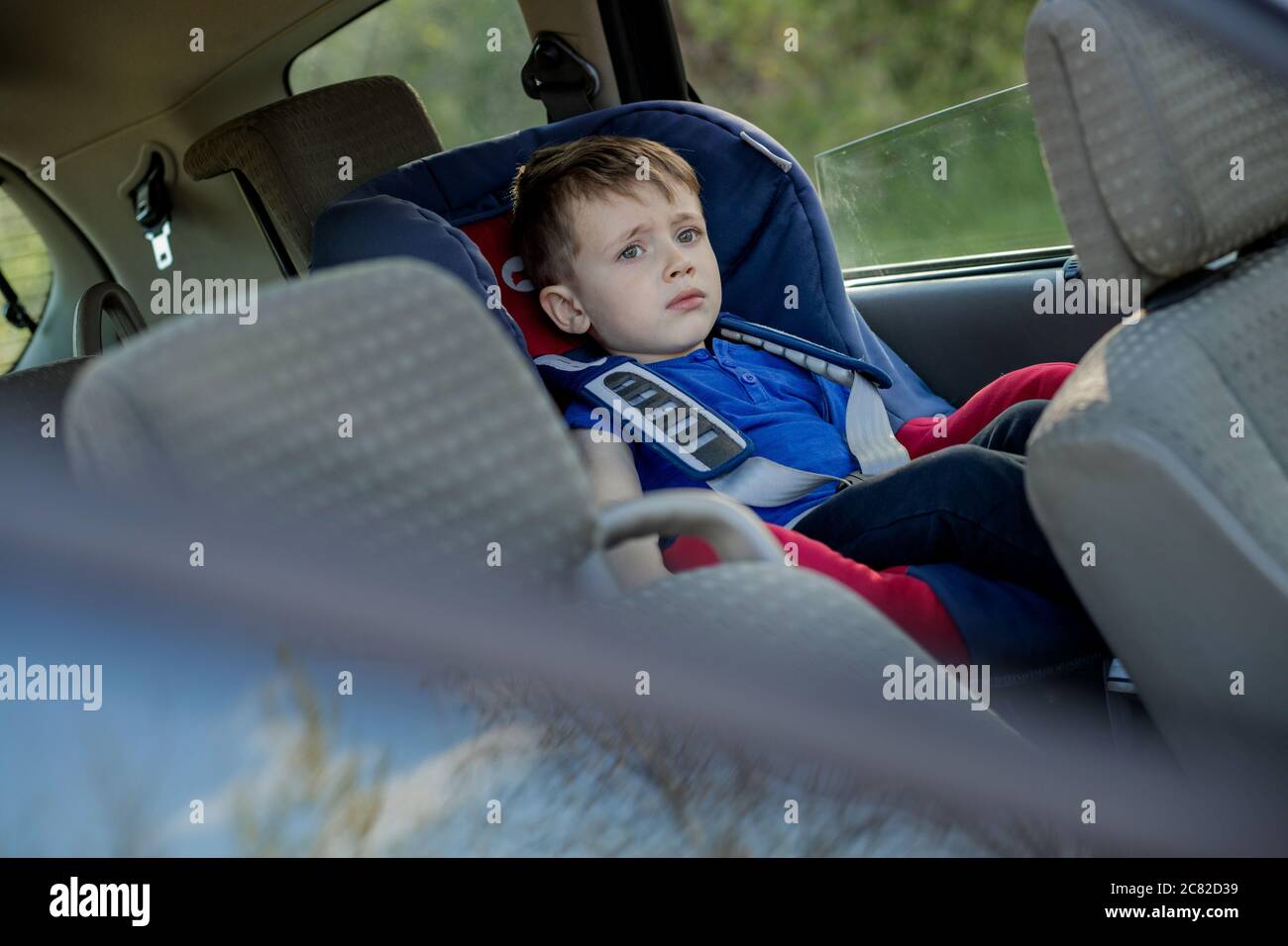 Le petit garçon a bouclé la ceinture de sécurité à l'intérieur de la  voiture. Véhicule et transport Photo Stock - Alamy