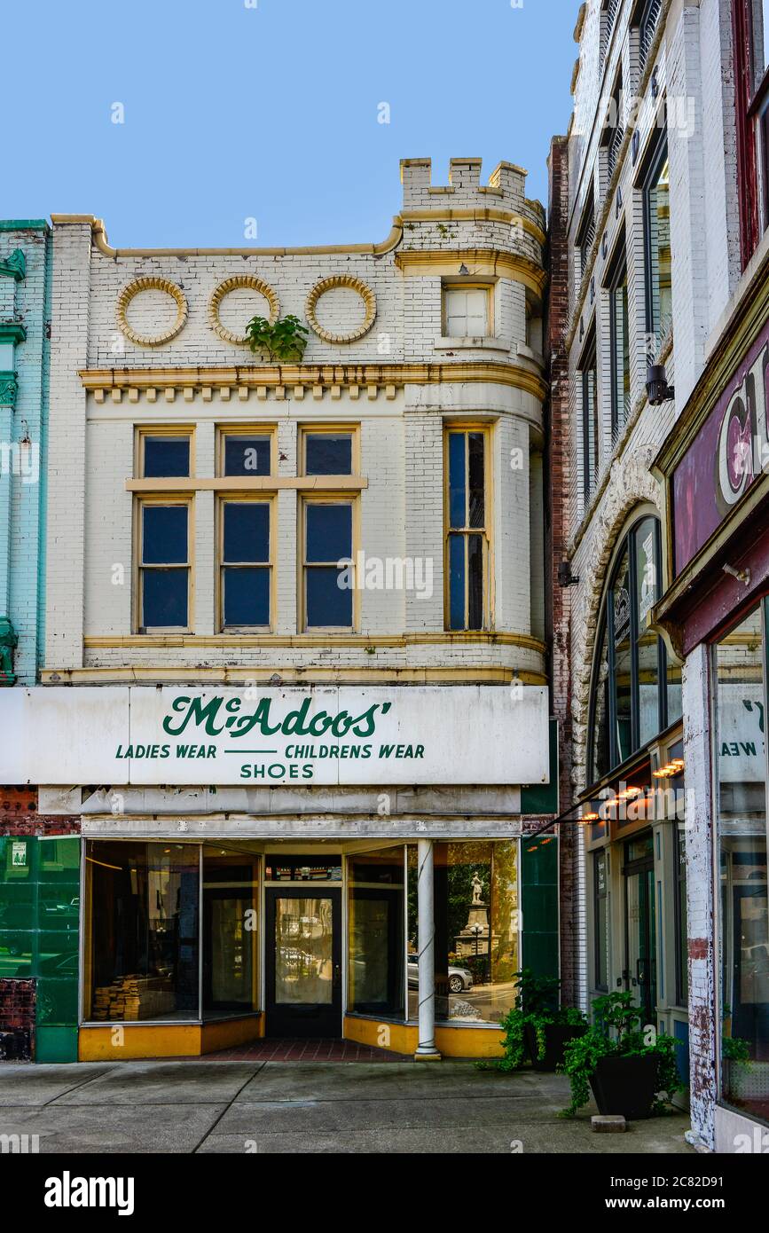 Un vieux magasin de vêtements abandonnés avec des signes décolorés et des éléments en décomposition sur la place de la ville au Liban, TN, USA Banque D'Images