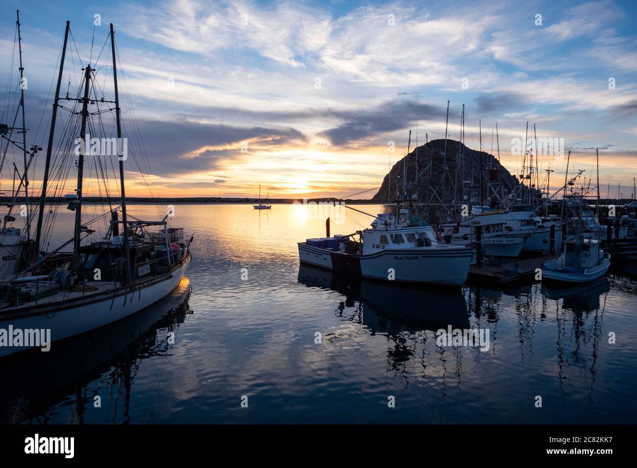 lumière dorée au coucher du soleil reflétée avec les bateaux de pêche à proximité dans le port de Morro Bay, Californie Banque D'Images