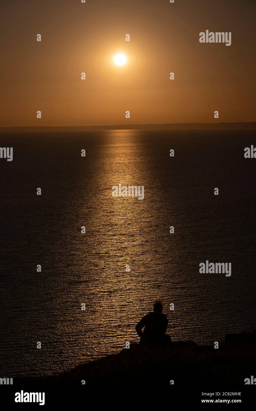 Portland, Angleterre. 20 juillet 2020. Silhouette d'un homme qui observe le soleil couchant sur West Bay sur l'île de Portland en Angleterre. L'île de Portand se trouve dans le comté de Dorset. (Photo de Sam Mellish / Alamy Live News) Banque D'Images