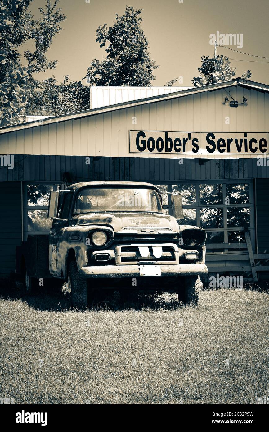 Un vieux camion Chevrolet rouillé stationné à la station de service de Fake Goober dans la ville de Fake Town dans la région rurale du Tennessee, aux États-Unis, dans un ton sépia Banque D'Images
