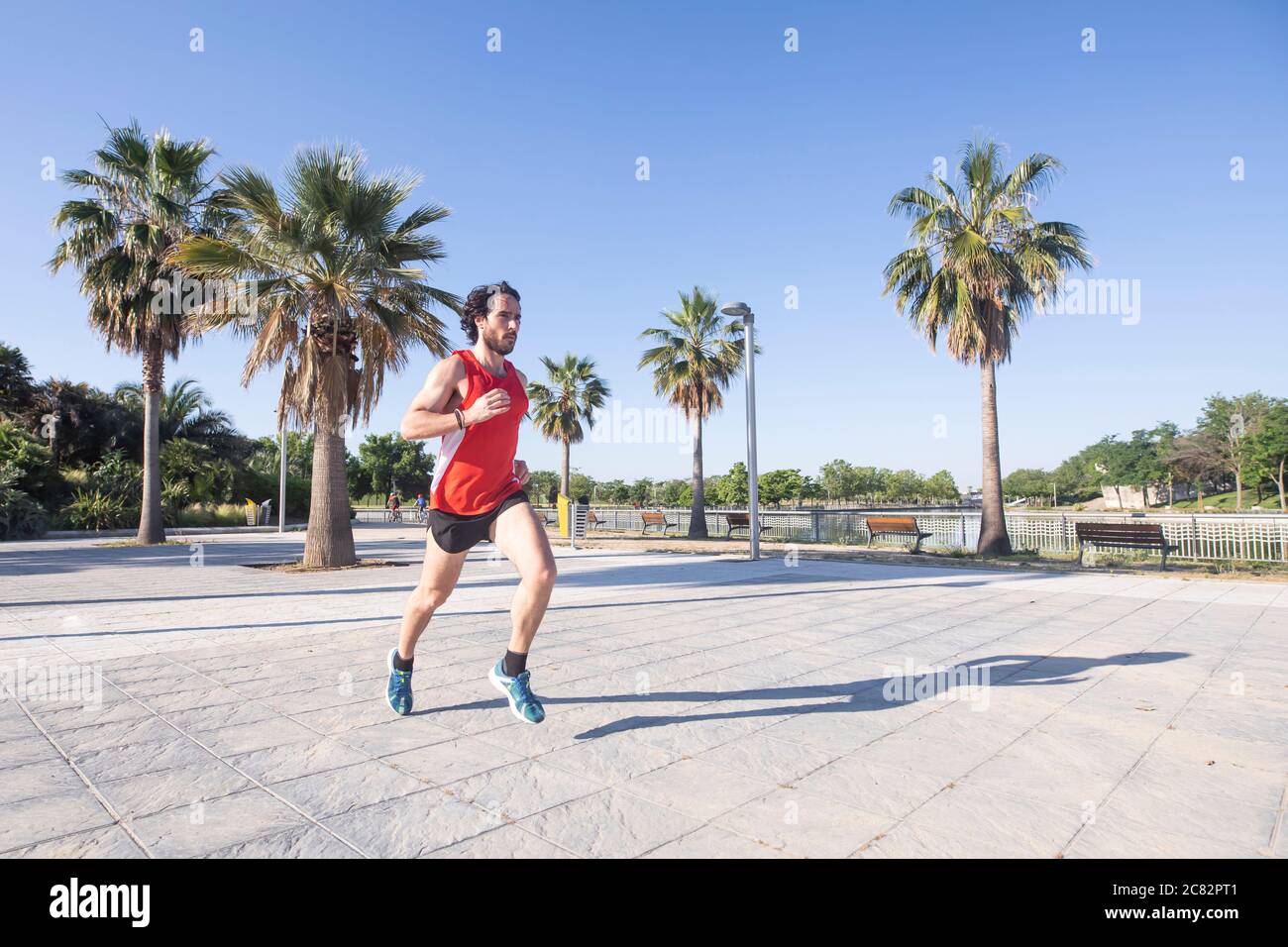 jeune homme courant dans le parc de la ville Banque D'Images