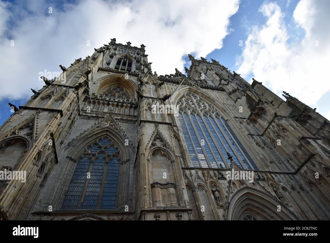 En regardant directement vers le haut les Western Towers of York Minster, vous créez un regard abstrait et spectaculaire. Les nuages remplissent le ciel. Yorkshire, Angleterre. Banque D'Images