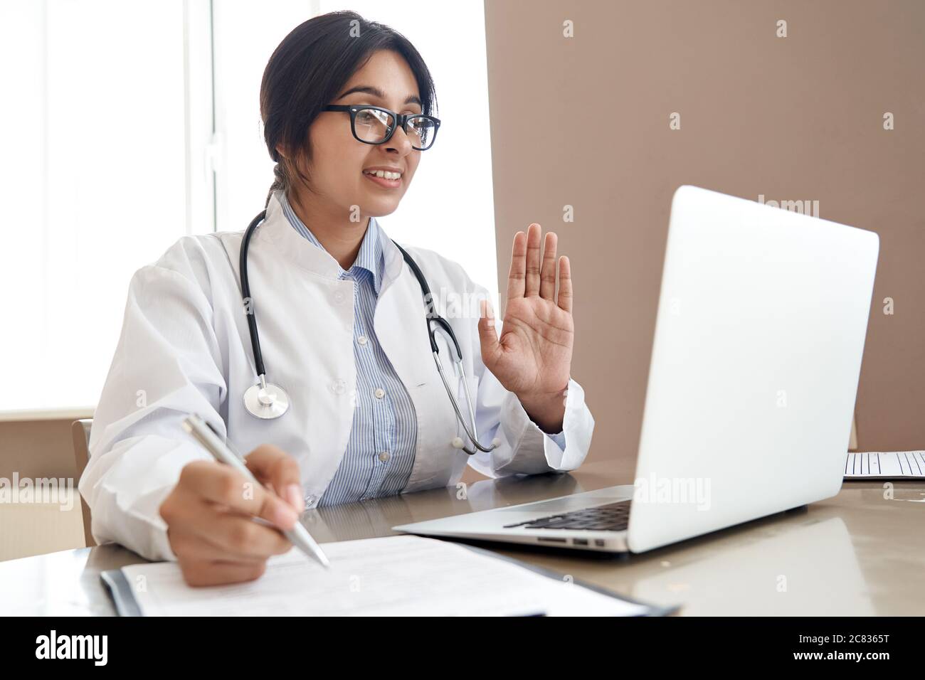 Une femme indienne parle au patient par vidéoconférence en ligne avec webcam. Banque D'Images