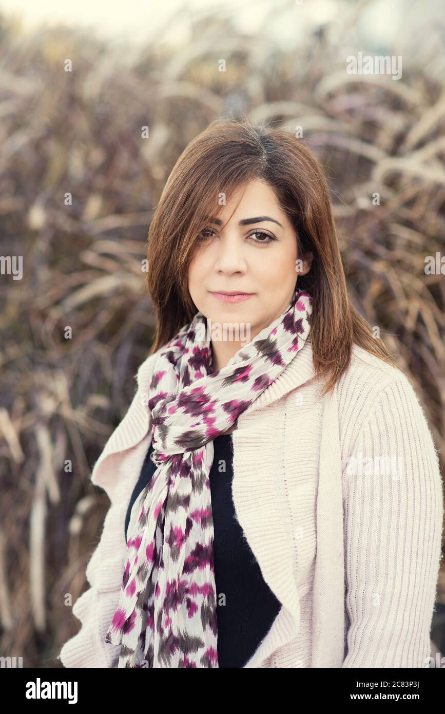 Belle femme du Moyen-Orient regardant l'appareil photo sourire à l'extérieur Banque D'Images