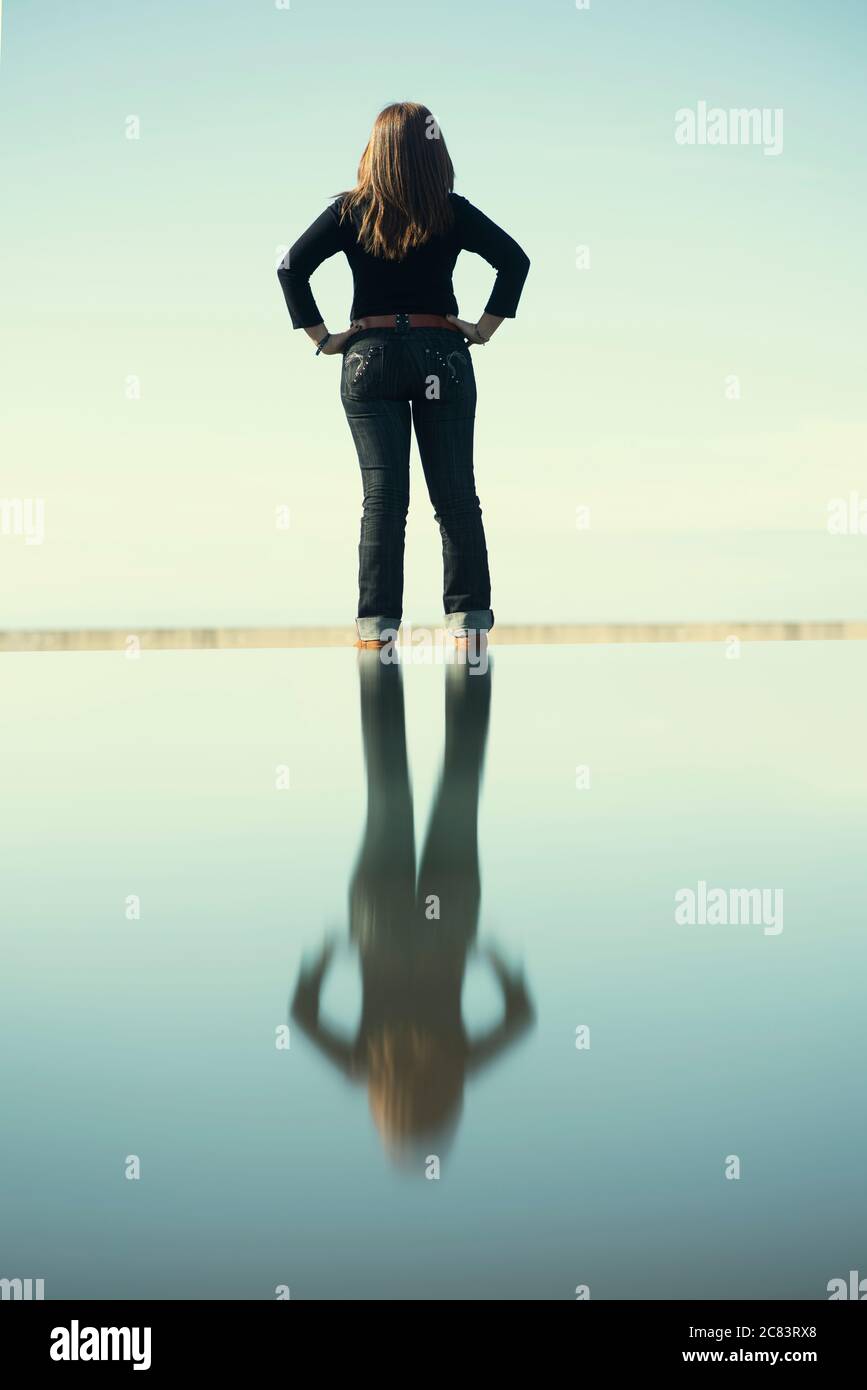 Vue arrière de la femme avec réflexion sur l'eau Banque D'Images