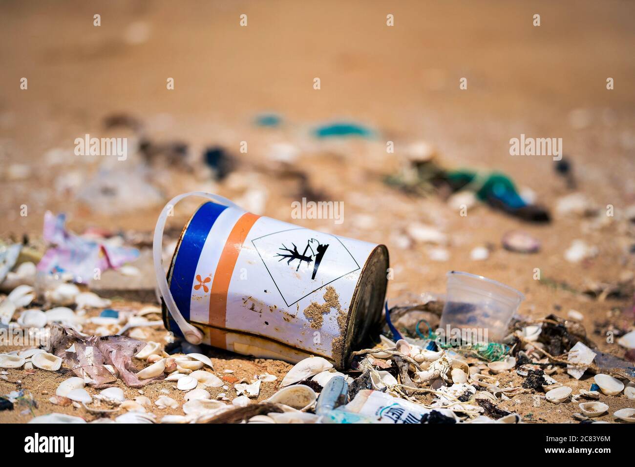 Un pot avec des produits chimiques toxiques sur un sable de plage. Problème de déchets dans l'océan. Banque D'Images