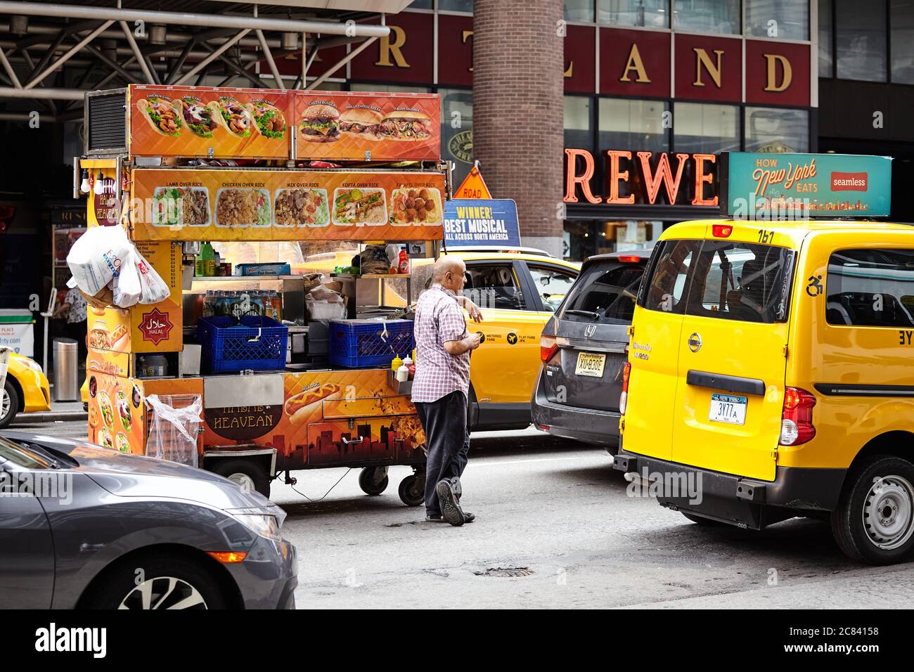 New York, USA - 28 juin 2018 : un homme avec une voiturette alimentaire attend dans un embouteillage dans la rue de Manhattan. Banque D'Images