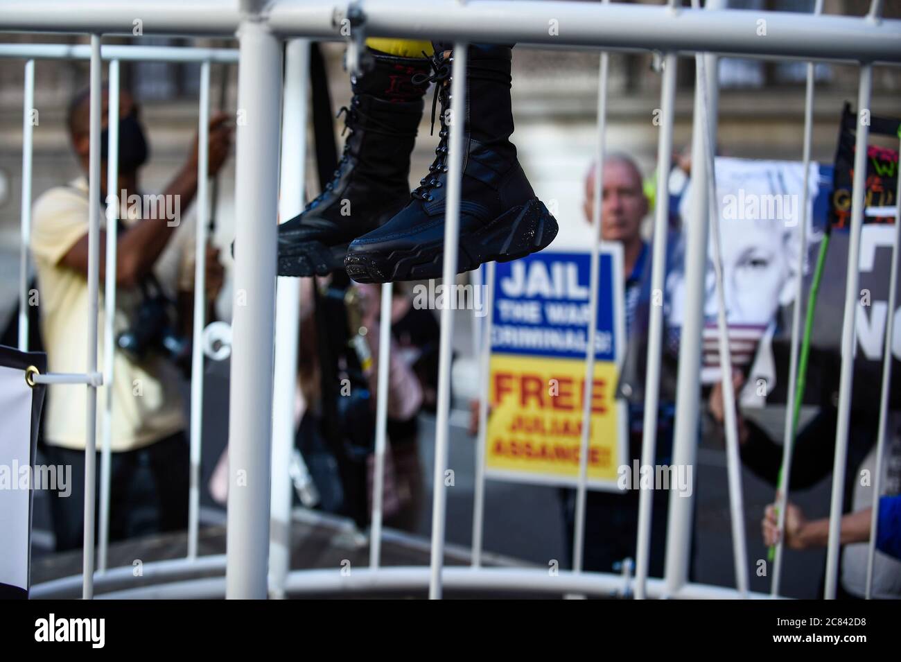 Londres, Royaume-Uni. 21 juillet 2020. Les bottes de Dame Vivienne Westwood qui, après avoir été blindées pendant le confinement de la COVID-19, sont accrochées dans une cage à oiseaux géante et suspendues à 10 pieds dans les airs devant le tribunal pénal d'Old Bailey pour protester contre le procès d'extradition américain de Julian Assange, Qui doit être de nouveau à l'Old Bailey le 7 septembre. Elle est habillée d'un costume à pantalon jaune, adoptant la métaphore de «l'canari dans la mine de charbon», qui indique que «Assange est sacrifié pour identifier «le poison» dans le système». Credit: Stephen Chung / Alay Live News Banque D'Images