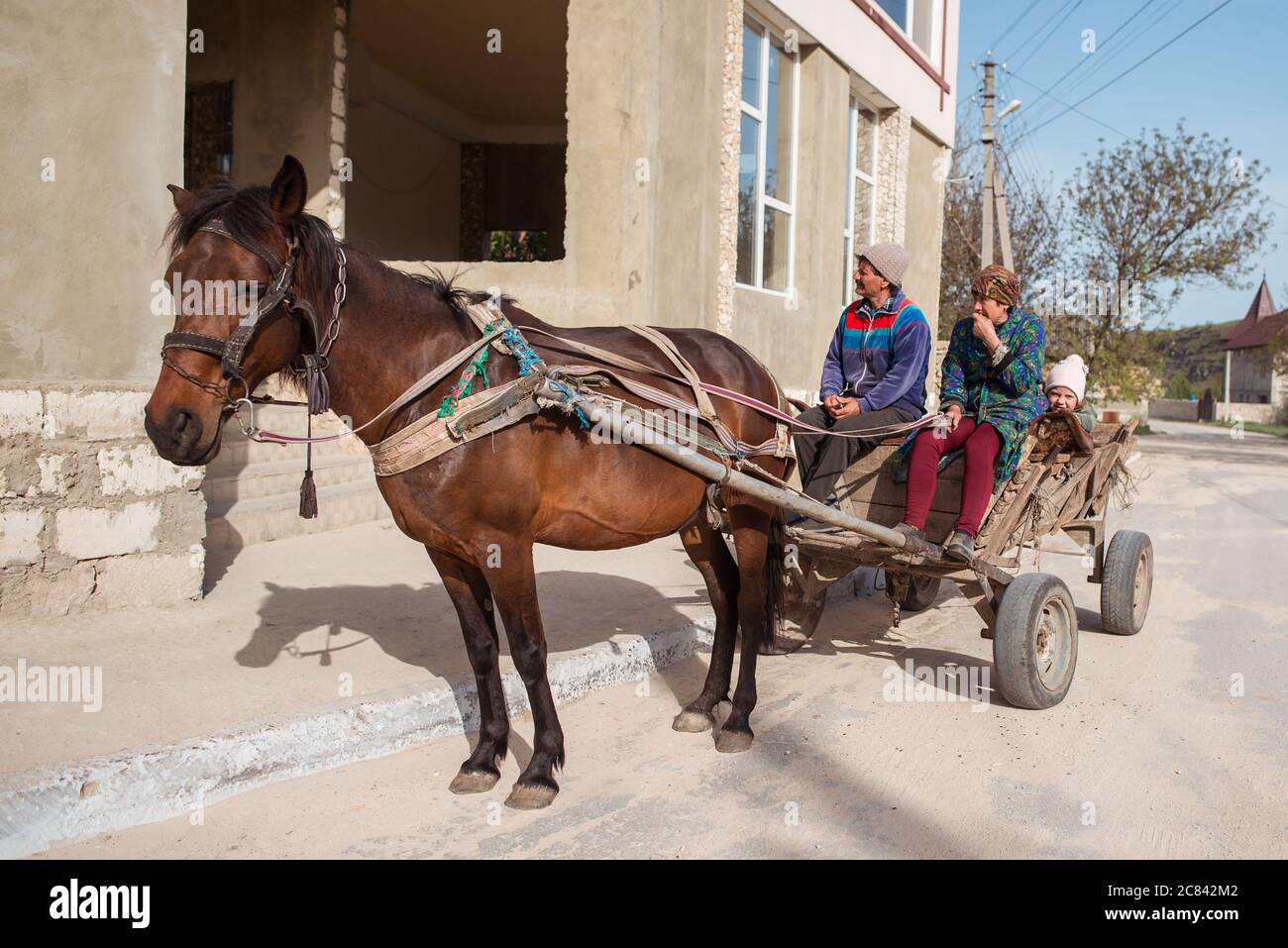 Trebujeni / Moldova - 15 mai 2020 : chariot en bois tiré par un cheval transportant une famille dans le village Banque D'Images