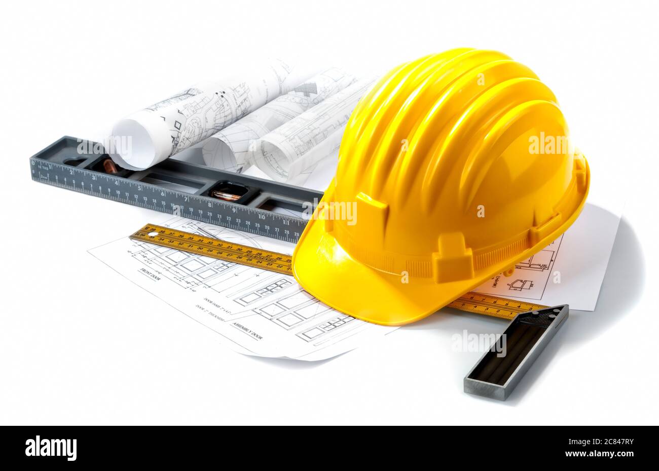 Casque jaune isolé avec outils et plan sur fond blanc. Banque D'Images
