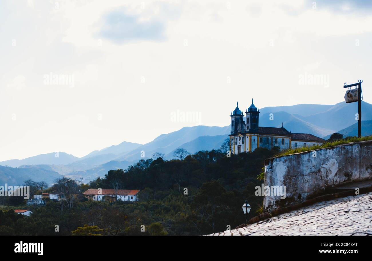 Église de Nossa Senhora das Mercês e Perdões située à Ouro Preto, Minas Gerais, vue de loin dans un après-midi nuageux avec des collines dans le backgrou Banque D'Images