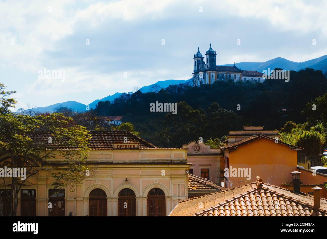 Église de Nossa Senhora das Mercês e Perdões située à Ouro Preto, Minas Gerais, vue d'une distance dans un après-midi nuageux avec des toits de la coloniale Banque D'Images