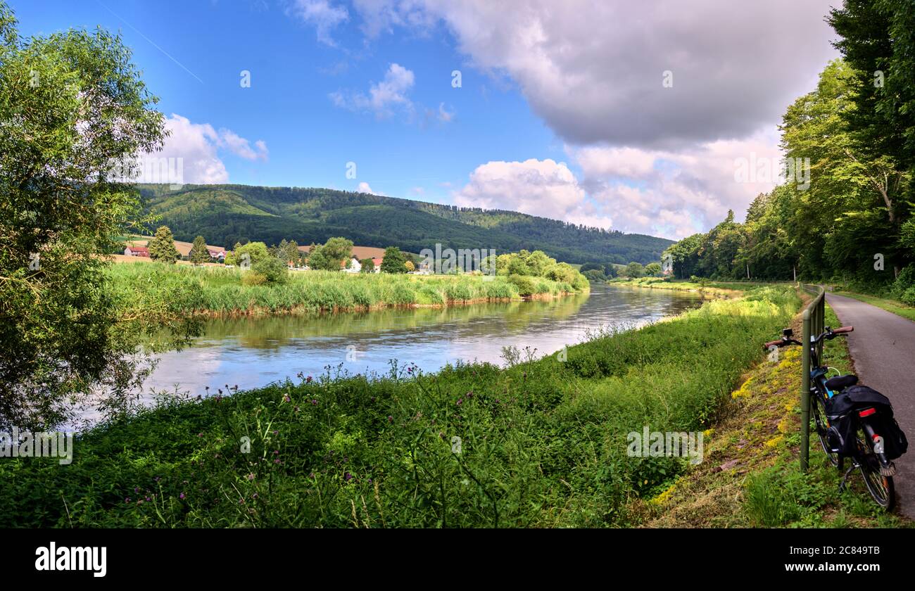 Panorama depuis le long chemin cyclable à côté du Weser en Allemagne dans le Weserbergland, avec des rives vertes et ciel nuageux Banque D'Images