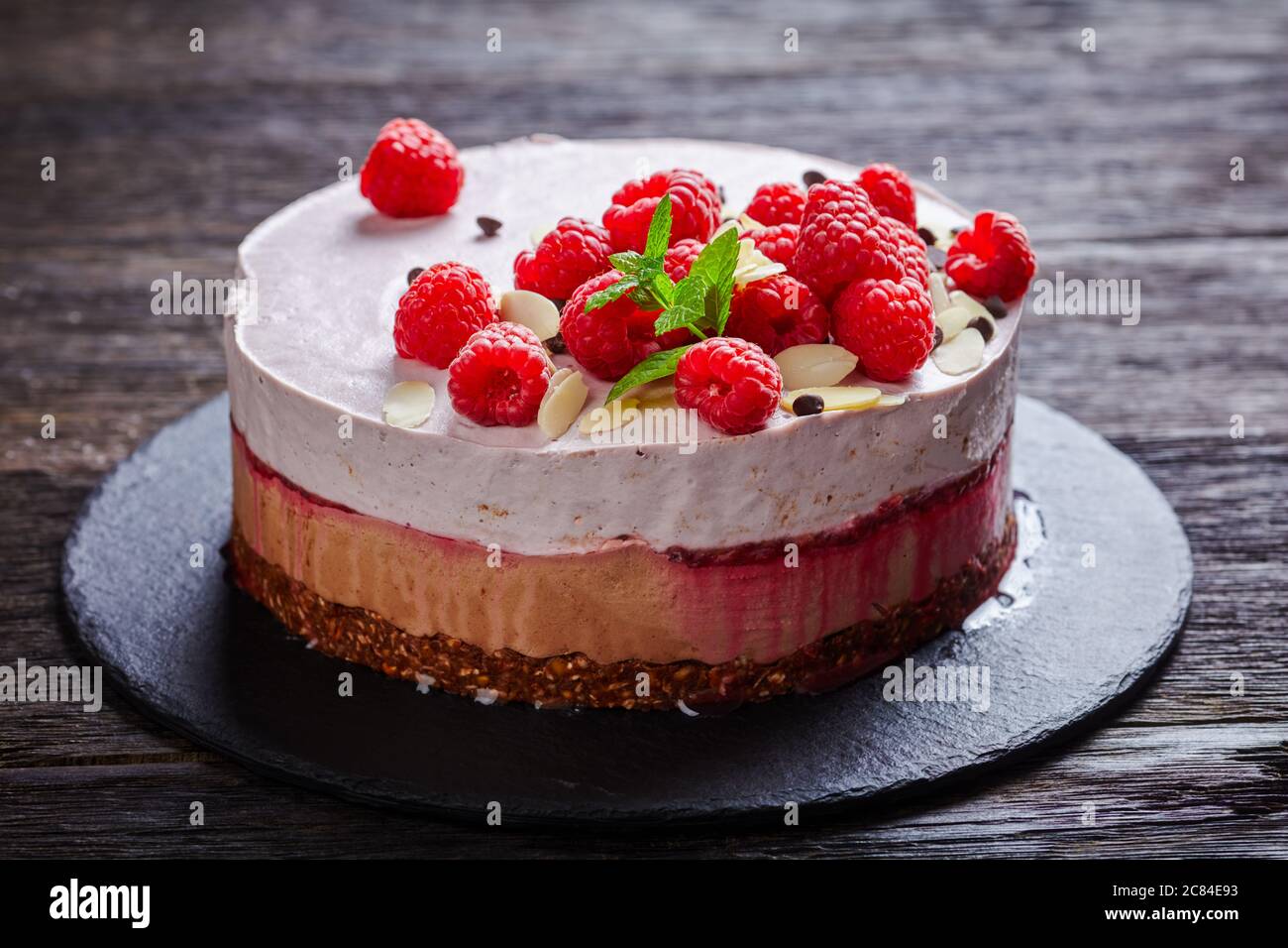 gros plan de gâteau à la crème glacée à la framboise sur une assiette noire en ardoise sur une table en bois sombre, vue sur le paysage depuis le haut Banque D'Images