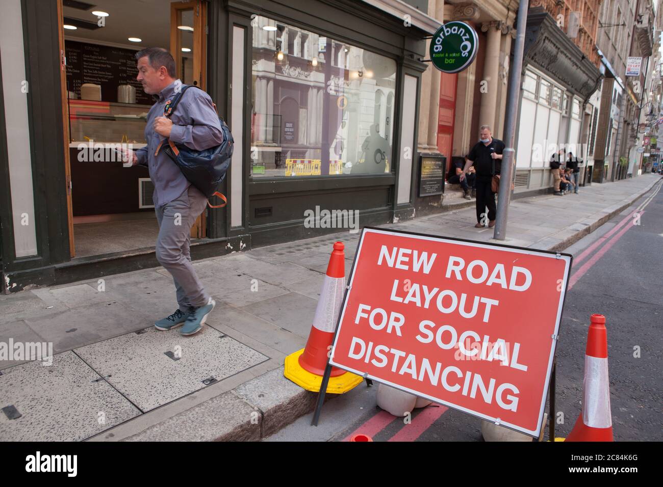 Londres, Royaume-Uni, 21 juillet 2020 : un panneau indique « New Road Layout for social distance », mais certaines personnes choisissent de ne pas se distancer de leurs collègues de travail. Malgré le Premier ministre Boris Johnson qui exhorte les gens à retourner au travail, la City de Londres est presque déserte. Habituellement, il serait trrongé avec les travailleurs et les touristes un matin de semaine. Anna Watson/Alay Live News Banque D'Images