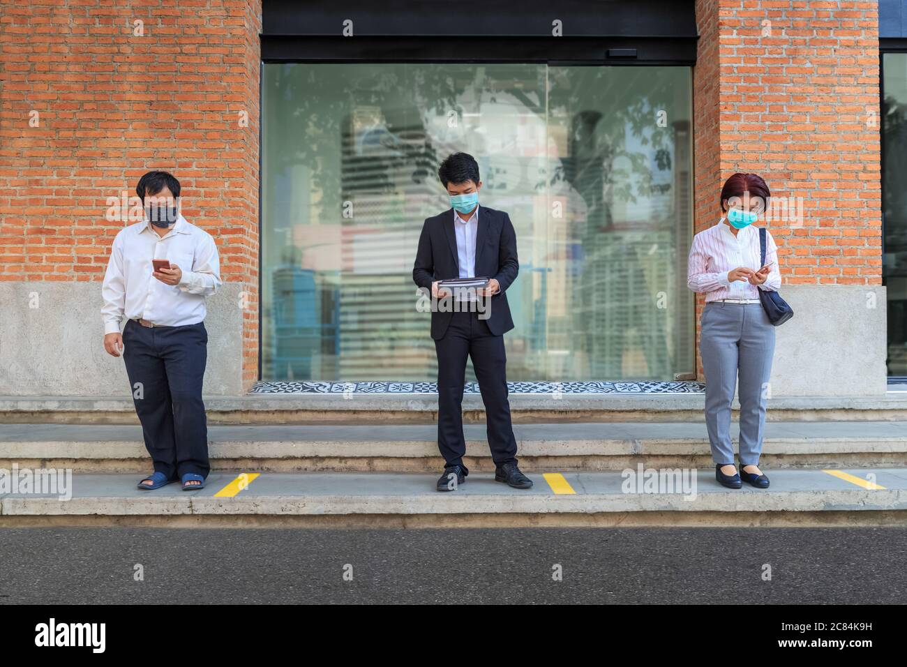 Les personnes d'âge moyen asiatique portent un masque et gardent des distances sociales pour éviter la propagation de COVID-19 Banque D'Images