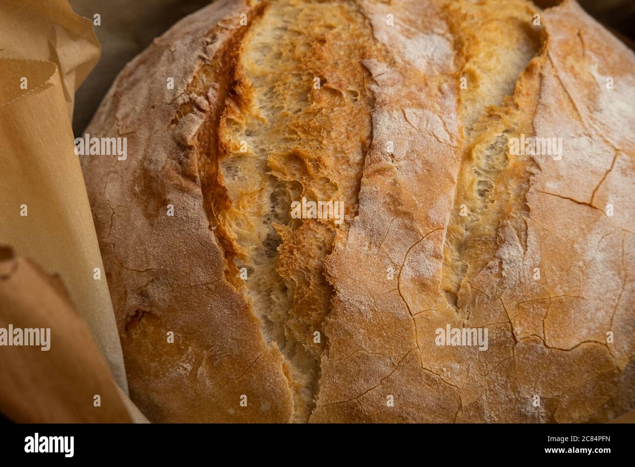 Gros plan de pain rustique en fonte avec papier parchemin, cuit au four Banque D'Images
