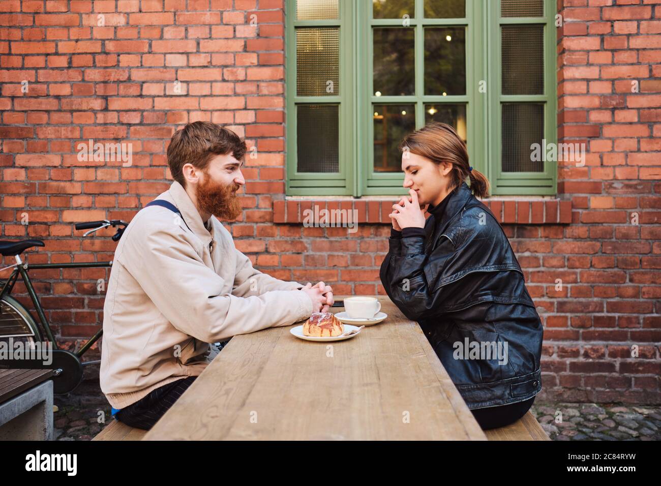 Vue latérale d'un couple magnifique se reposant ensemble dans un café de rue Banque D'Images