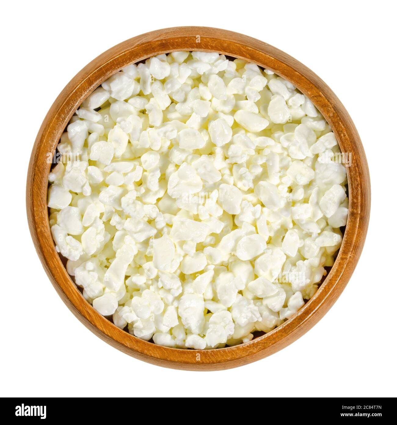 Fromage cottage grains de caillé dans un bol en bois. Igredient pour faire un produit de caillé de fromage frais également connu sous le nom de caillé et de lactosérum, avec une saveur douce. Banque D'Images