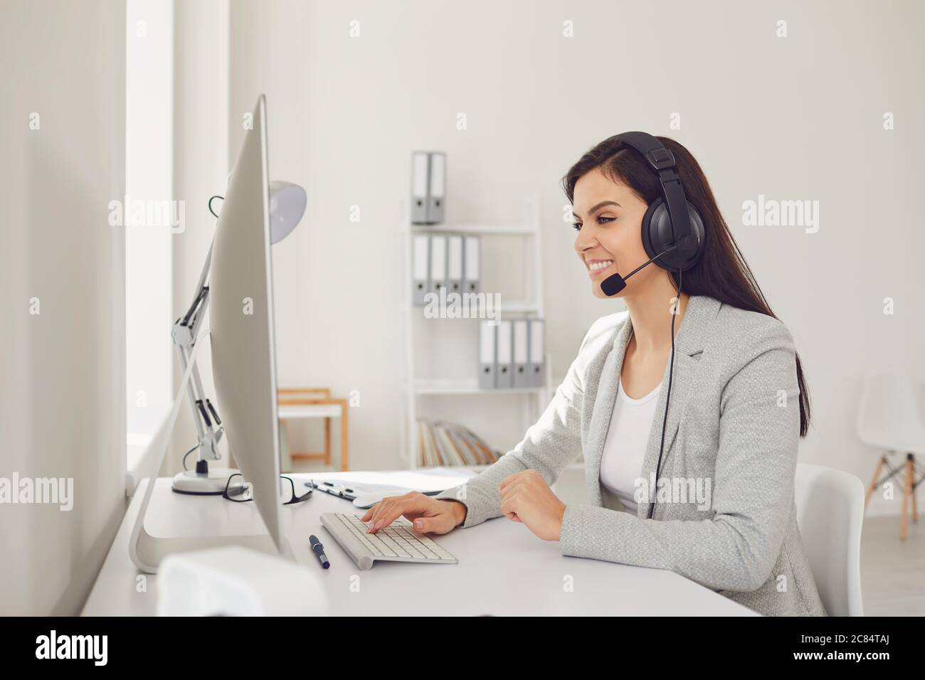 Opérateur de centre d'appels femme dans un casque assis à un ordinateur sur le lieu de travail. Centre d'assistance en ligne concept Banque D'Images