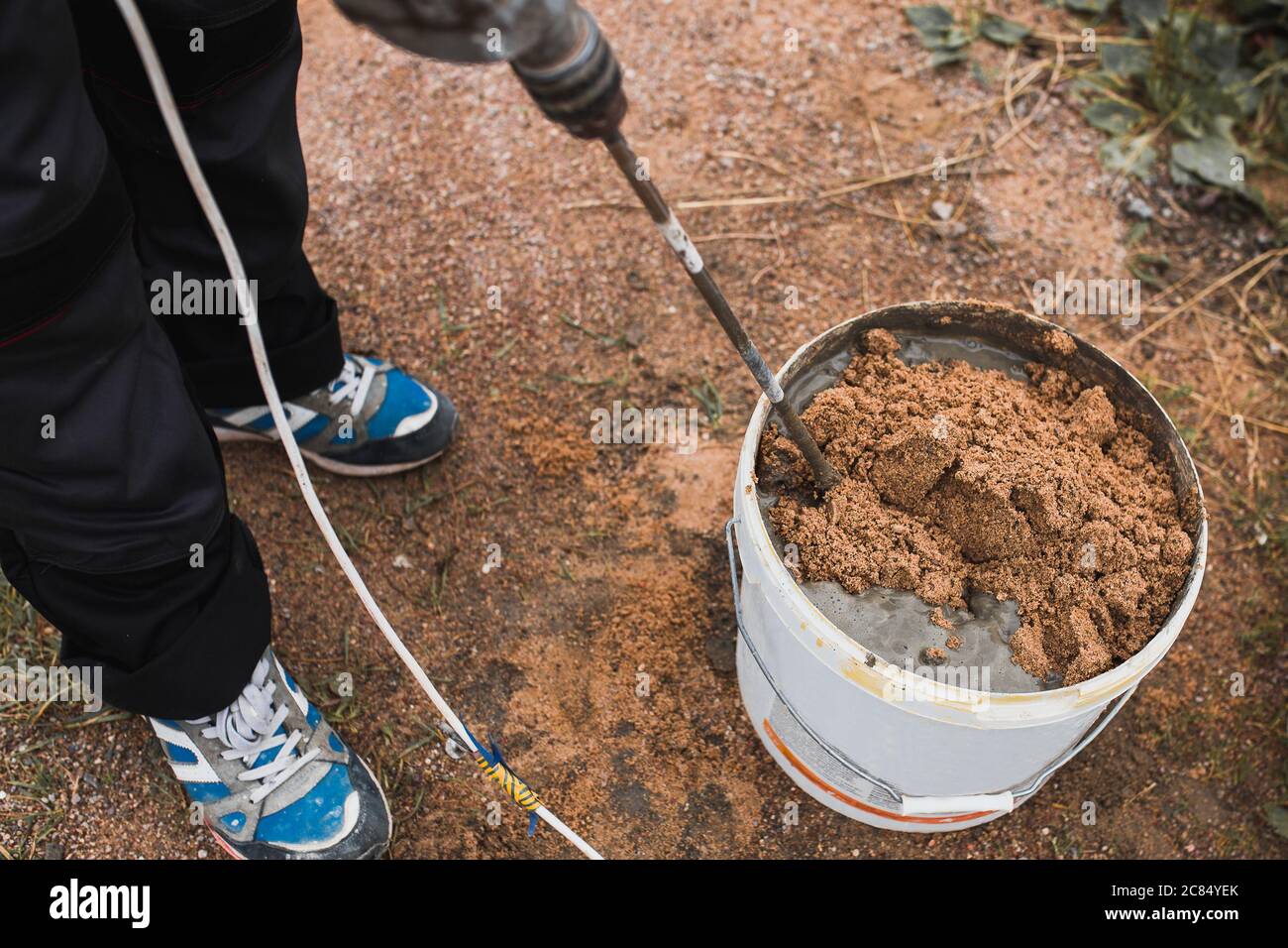 Préparation de mortier de colle de ciment dans un seau de ciment et de  sable à l'aide d'un mélangeur sur une perceuse - le travail d'une couche de  brique professionnelle Photo Stock -