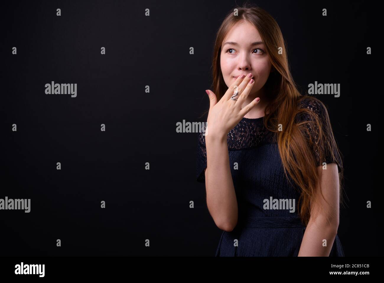 Jeune belle femme avec de longs cheveux bruns sur fond noir Banque D'Images