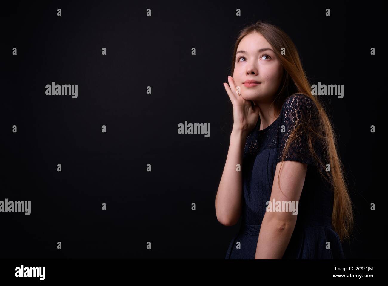 Jeune belle femme avec de longs cheveux bruns sur fond noir Banque D'Images