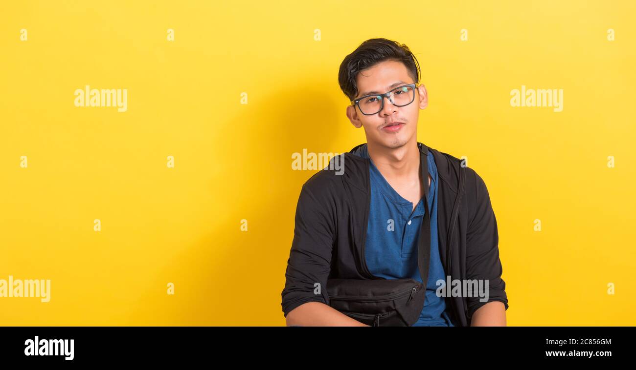Portrait de tête de jeune asiatique homme de main porte des lunettes ou des lunettes, court de studio isolé sur fond jaune avec espace de copie, Fashion masculin Banque D'Images