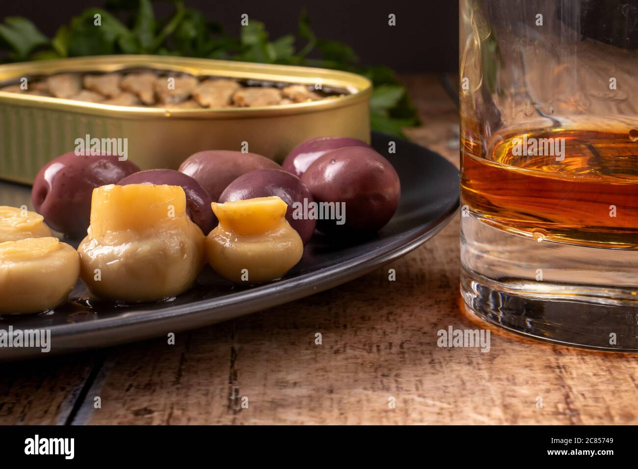 Un verre de whisky et un hors-d'œuvre d'élite. Olives, champignons marinés, champignons, sprat et une boisson alcoolisée chère. Banque D'Images