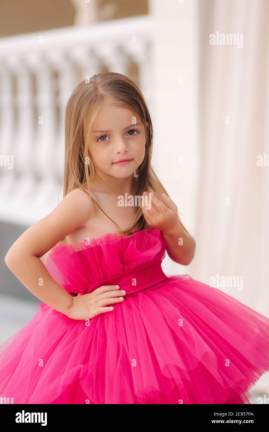 Adorable petite fille modèle dans la robe rose duveteuse posant au  photographe Photo Stock - Alamy