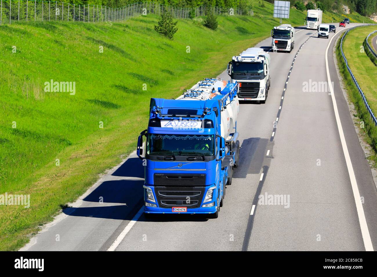 Quatre camions, camions-citernes Volvo FH et camion-plateforme Scania sur l'autoroute, un beau jour d'été. Salo, Finlande. 12 juin 2020. Banque D'Images