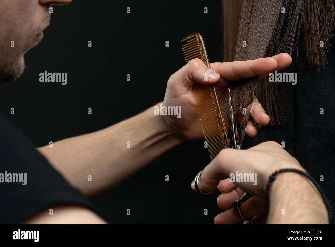Un gros plan de coiffeur mains couper les cheveux, coiffeur avec le client Banque D'Images