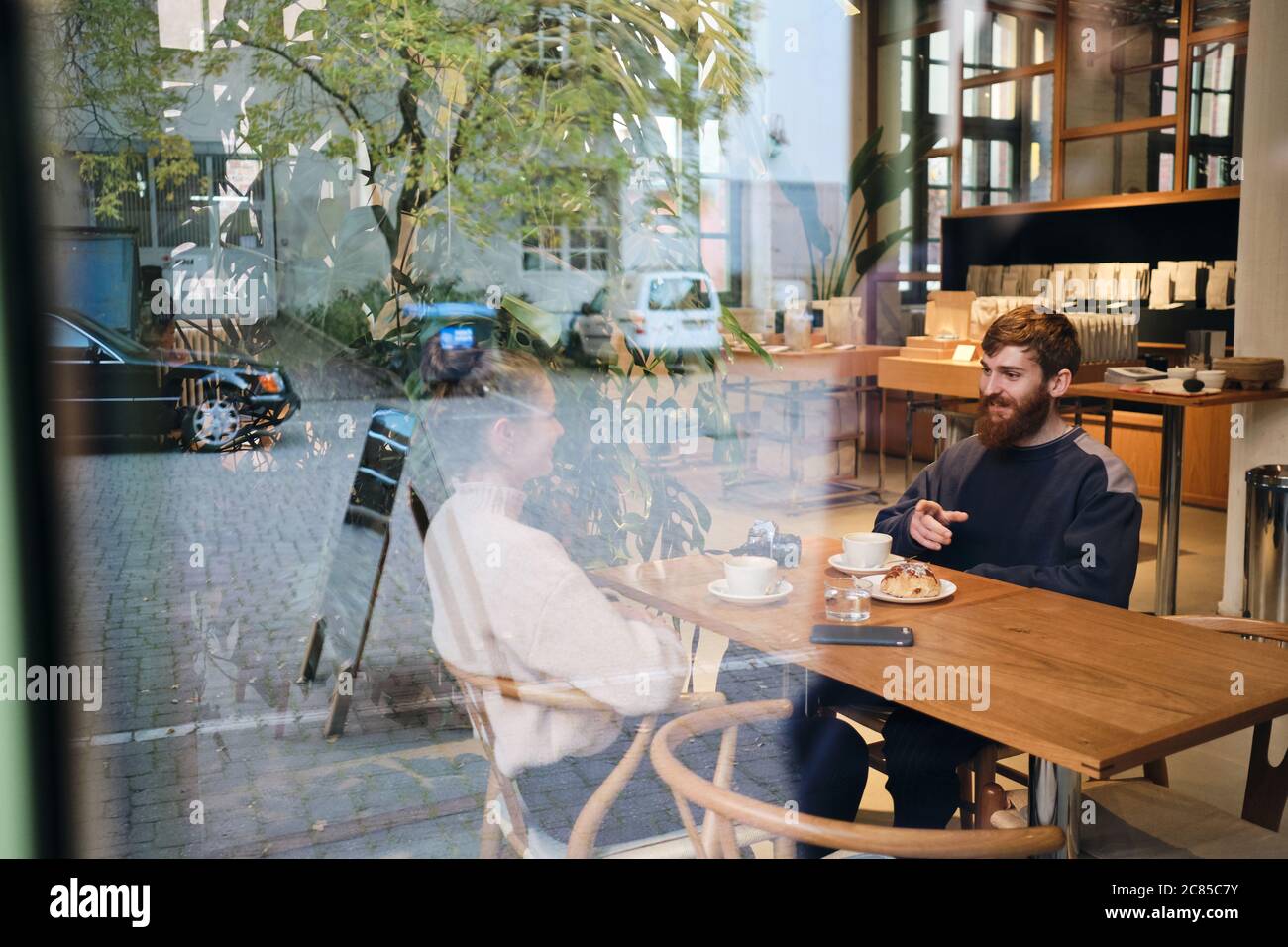 Jeune beau couple qui parle avec joie pendant la pause-café au café Banque D'Images