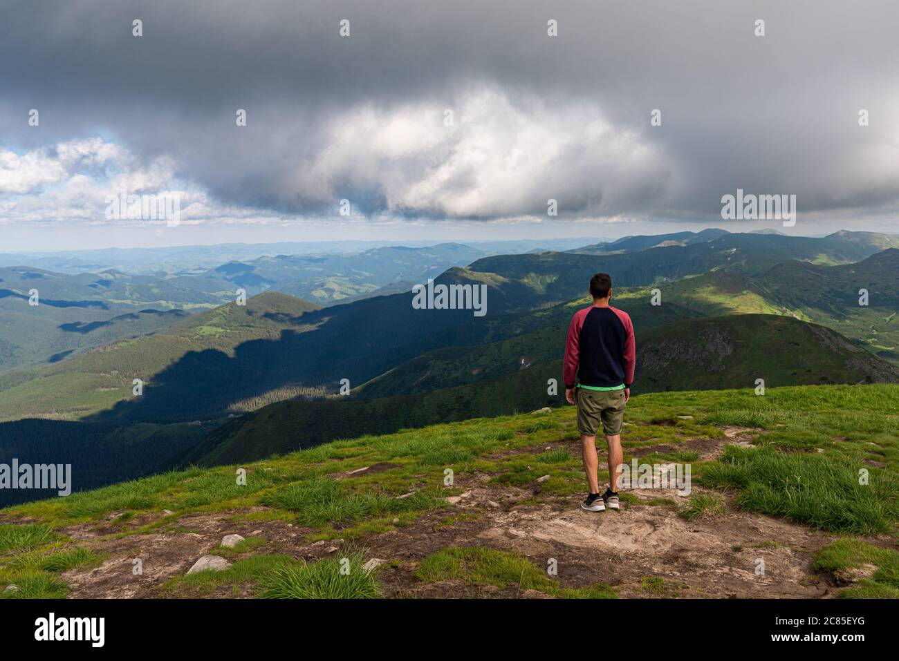 Voyageur debout sur la falaise de haute montagne, en admirant le paysage au sommet de la montagne. Vue POV. Concept de liberté de randonnée Banque D'Images
