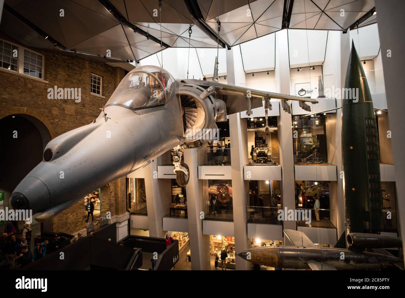 Imperial War Museum Harrier Jump Jet Londres // LONDRES, Royaume-Uni — Un jet de saut Harrier est suspendu au-dessus du hall principal de l'Imperial War Museum à Londres. L'emblématique avion de fabrication britannique, connu pour ses capacités de décollage et d'atterrissage verticaux, sert de pièce maîtresse d'exposition dans la vaste collection d'objets militaires du musée. Le Harrier, développé dans les années 1960, a révolutionné l'aviation militaire en tant que premier chasseur à réaction opérationnel avec des capacités de décollage et d'atterrissage verticaux/courts. Le musée impérial de la guerre, situé dans l'ancien bâtiment de l'hôpital royal de Bethlem, documente un Banque D'Images