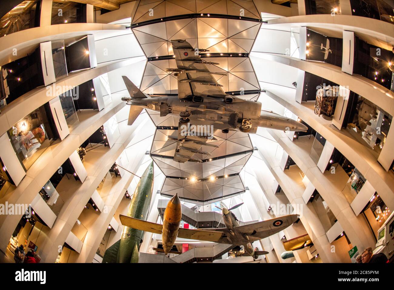 LONDRES, Royaume-Uni — Une vue spectaculaire regardant vers le haut des avions militaires suspendus dans l'atrium central de l'Imperial War Museum London. L'espace récemment redessiné du musée présente des avions emblématiques de divers conflits, dont un chasseur Spitfire et un jet de saut Harrier, créant une exposition visuelle saisissante qui présente aux visiteurs l'histoire de l'aviation militaire britannique. Banque D'Images