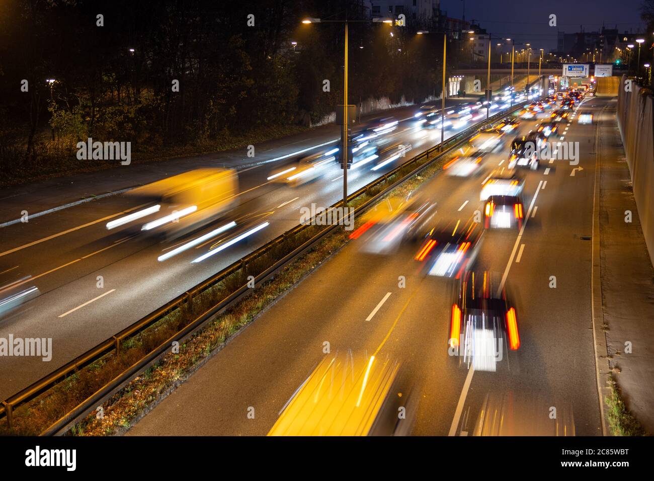 La circulation rapide passe le long d'une autoroute allemande qui mène du centre-ville de Munich à l'aéroport pendant la nuit de pointe. Banque D'Images