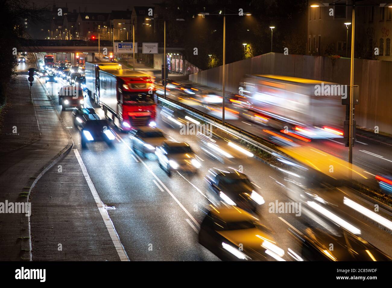 La circulation rapide passe le long d'une autoroute allemande qui mène du centre-ville de Munich à l'aéroport pendant la nuit de pointe. Banque D'Images
