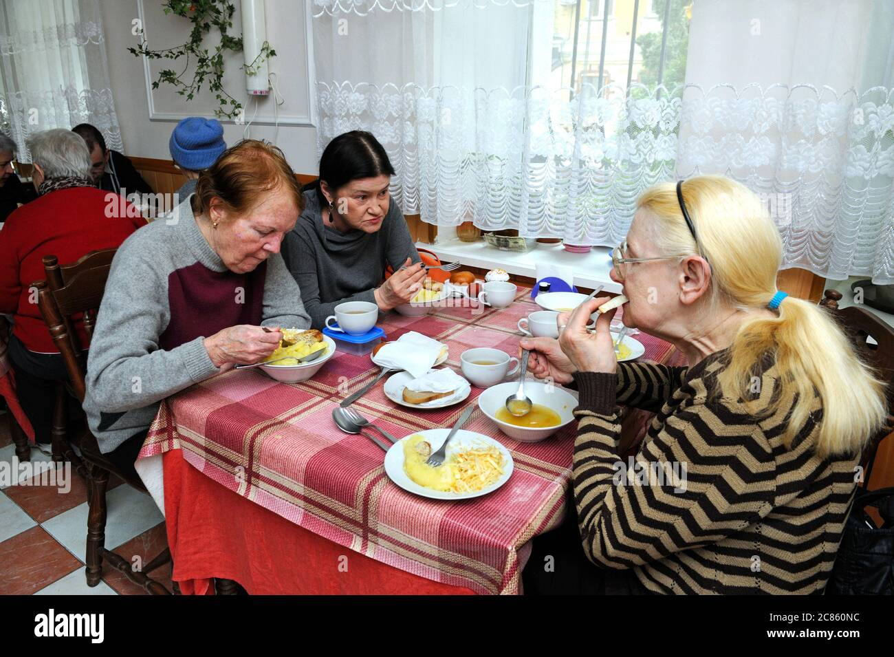 À la cantine. Les personnes âgées s'asseyant à une table et ayant un dîner gratuit pour les pauvres. Ouverture du centre des services sociaux du district de Pechersky à Kiev. AP Banque D'Images