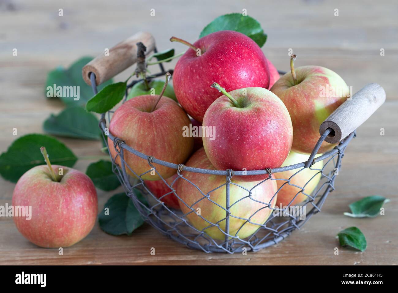pommes fraîches dans un panier sur une table en bois Banque D'Images