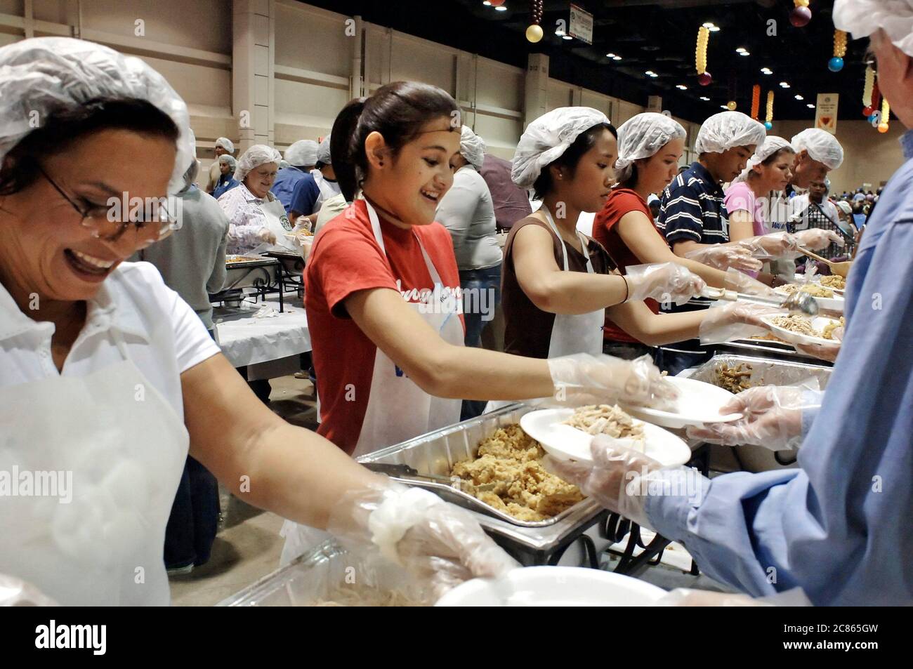 San Antonio, Texas États-Unis, 24 novembre 2005 : les adolescents hispaniques du secondaire mettent de la nourriture dans des assiettes lors du dîner annuel de Thanksgiving Raul Jiminez, où plus de 25 000 repas le jour de Thanksgiving sont servis pour les personnes âgées, les sans-abri, les pauvres et les déplacés du sud du Texas. L'événement, créé par le défunt restaurateur Raul Jiminez, en est à sa 26e année. ©Bob Daemmrich Banque D'Images
