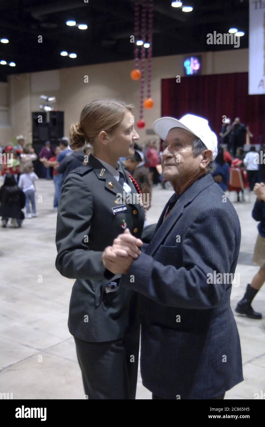 San Antonio, Texas États-Unis, 24 novembre 2005 : une personne âgée dansant avec une recrue du lycée JROTC au 26e dîner annuel de Thanksgiving Raul Jiminez où plus de 25 000 repas sont servis le jour de Thanksgiving pour les personnes âgées, sans-abri, pauvres et déplacés du sud du Texas. ©Bob Daemmrich Banque D'Images